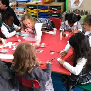 reception students cutting and sticking