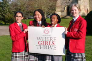 students holding a where girls thrive sign